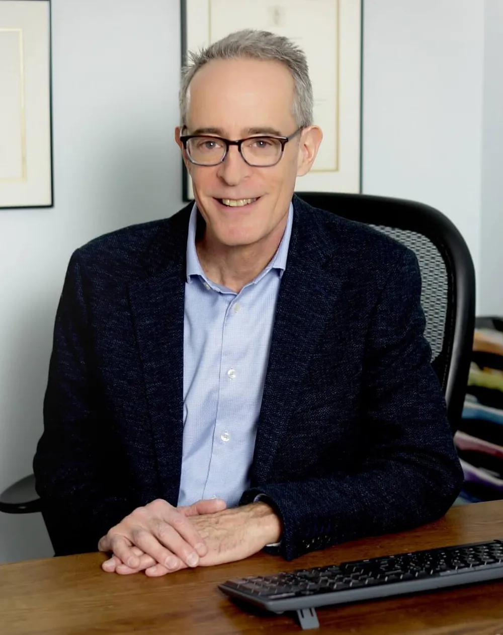 Dr. Jonathan Taylor seated at a desk wearing a dark blazer and light dress shirt